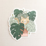 A curious cat settles among lush monstera leaves, tucked into the calm greenery of a Wildflower Woods cottage. This vinyl sticker captures that cozy, plant-filled moment, bringing a touch of quiet charm to your everyday essentials.

Made from durable, waterproof vinyl, this sticker is designed to hold up wherever you place it—whether that’s a water bottle, laptop, or journal you reach for daily.