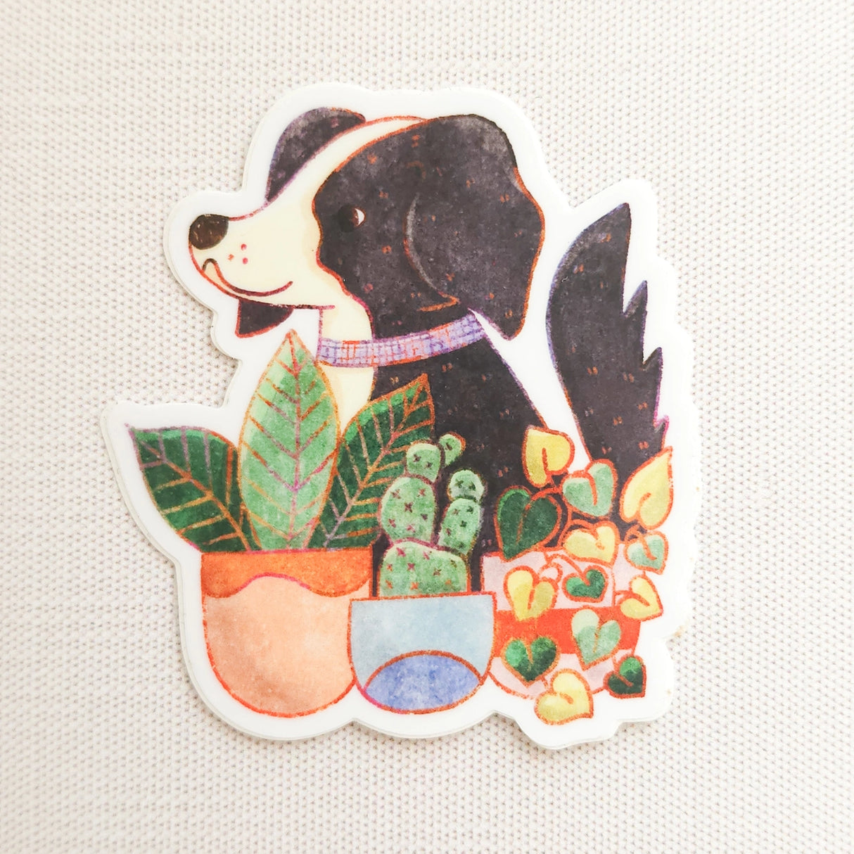 A loyal dog settles in among leafy houseplants, content to rest where sunlight filters softly through the greenery. This vinyl sticker captures that familiar, cozy moment, adding a quiet sense of companionship to your everyday essentials.

Made from durable, waterproof vinyl, this sticker is designed to hold up wherever you place it—whether that’s a water bottle, laptop, or journal you reach for daily.