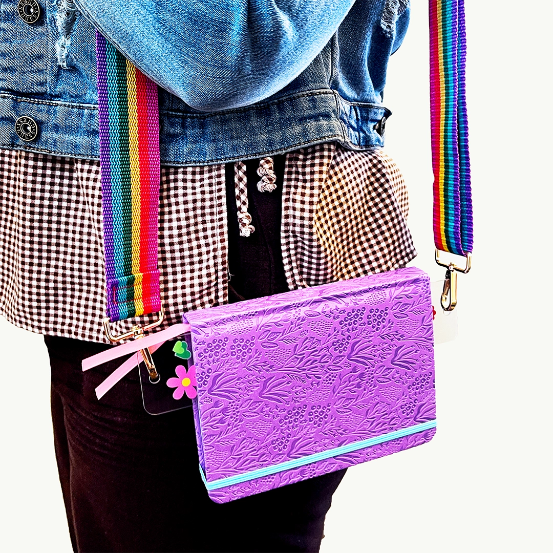 Take your current read anywhere! This rainbow strap turns your favorite book or journal into an instant crossbody so you can read on the go, hands-free and in style. Perfect for book lovers, travelers, and sticker-covered notebooks alike!




