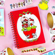 A tiny notebook with major main character energy 🍓💌 Covered in the sweetest strawberry + Hello Kitty details, it’s perfect for quick notes, doodles, and lists you’ll actually want to write. Small enough to toss anywhere, cute enough to show off everywhere.

A bright red spiral notebook featuring Hello Kitty sitting in a strawberry, framed with a white scalloped oval and tiny floral details 🍓 The smooth cover pops with bold color, while inside you’ll find lined pages with coordinating strawberry accents a