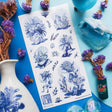 💐🌀 Step into @so.meurdok’s surreal garden, where faces, hands, feet, and figures blossom into living bouquets. Lush florals and striking blue details blur the line between body and bouquet, while foil accents trace every elegant curve like enchanted brushstrokes. A tiny art gallery, now in sticker form. Art by: @so.meurdok

Top Coating: Blue foil
Adhesive Layer: Paper
Backing Layer: Paper
6.69" x 3.54".
Weight - 0.03lbs
1 sheet included