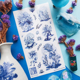 💐🌀 Step into @so.meurdok’s surreal garden, where faces, hands, feet, and figures blossom into living bouquets. Lush florals and striking blue details blur the line between body and bouquet, while foil accents trace every elegant curve like enchanted brushstrokes. A tiny art gallery, now in sticker form. Art by: @so.meurdok

Top Coating: Blue foil
Adhesive Layer: Paper
Backing Layer: Paper
6.69" x 3.54".
Weight - 0.03lbs
1 sheet included