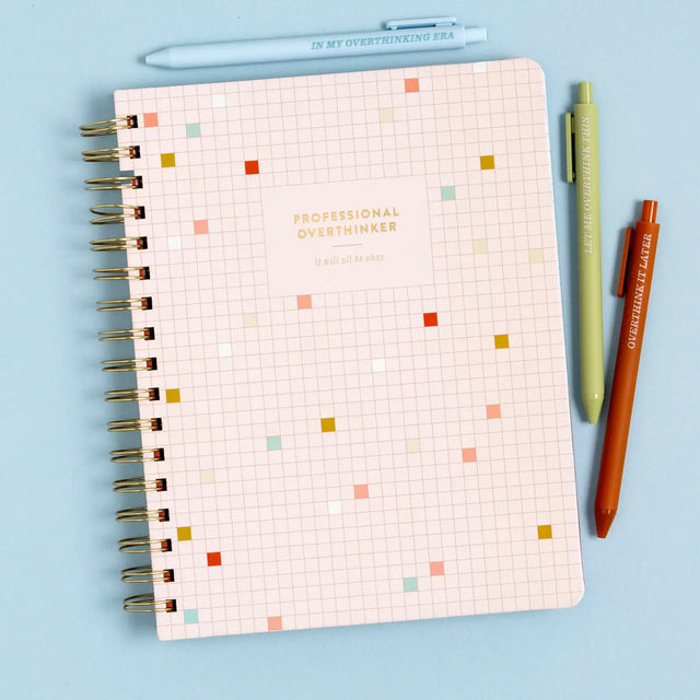 Stay organized and inspired with the Professional Overthinker Spiral Notebook! Featuring lined pages for all your thoughts, lists, and brainstorms, this 7” x 9” wire-bound notebook is perfect for journaling, note-taking, or planning your next big idea. The playful cover design makes it a great desk companion or a fun gift for students, writers, teachers, or anyone who loves to jot things down. Whether you’re tackling to-do lists or letting your creativity flow, this stylish and functional notebook is here t