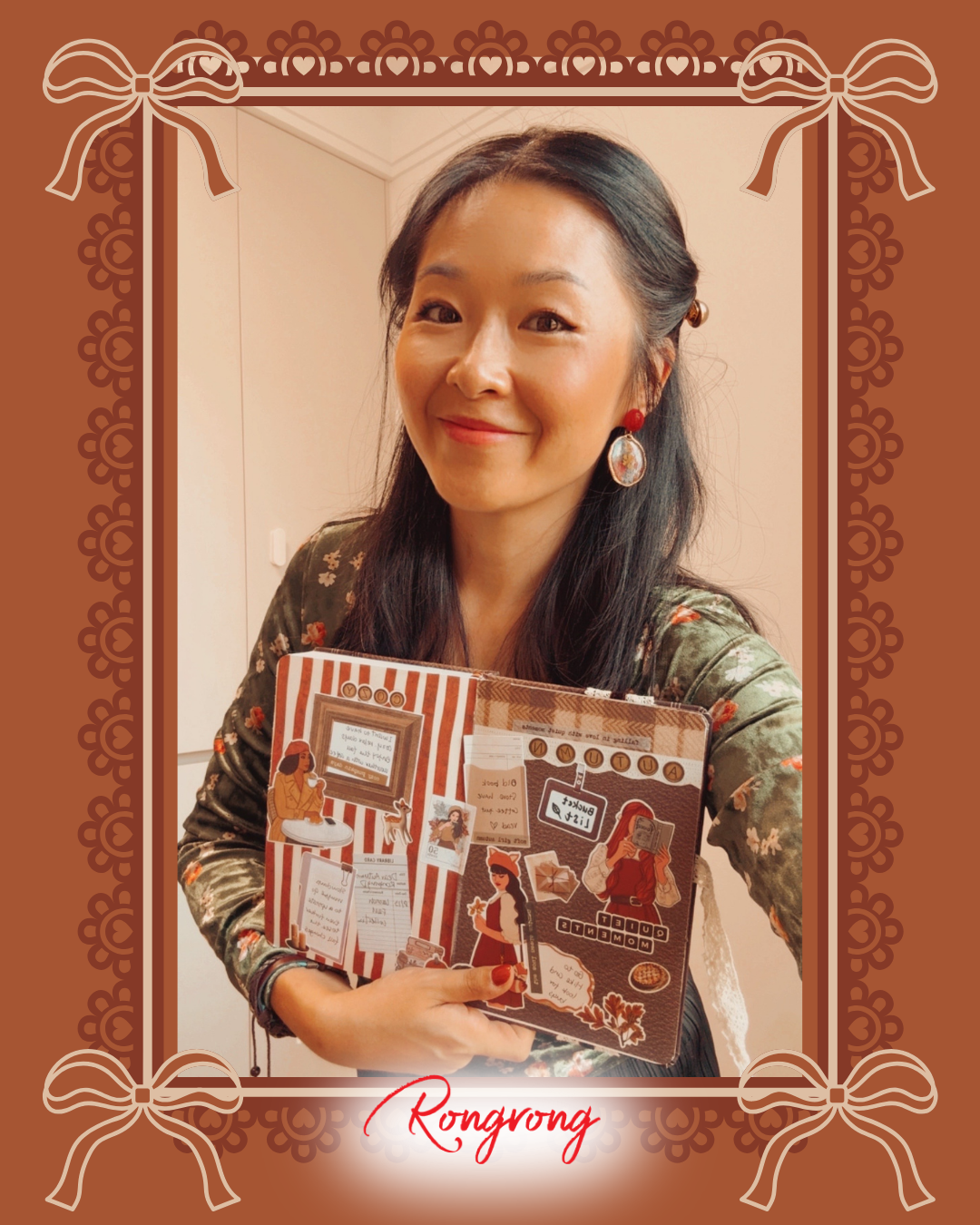 A woman with long black hair holds a handmade scrapbook journal with a rustic, vintage-style cover. She is wearing a patterned green top and red earrings, set against a warm indoor background.