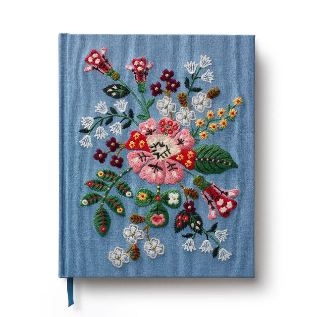 Our embroidered sketchbook is a large, hardcover journal with 108 unlined pages, perfect for sketching, drawing, and journaling. The cover is wrapped in blue book cloth and embroidered with our Gracie florals. Inside, an attached grosgrain ribbon bookmark will save your place.