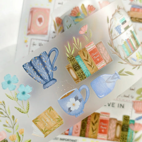 Slow down, get cozy, and lose yourself in a good book with Take Time To Read Pre-cut PET Tape 3.0 — a warm and nostalgic collection made for book lovers and journaling enthusiasts.

This tape features beautiful bookshelves, stacks of novels, cozy reading corners, teacups, lamps, plants, and charming literary details in rich vintage tones. Every piece is designed to create comforting, story-filled spreads that celebrate the joy of reading and quiet moments.

Because the designs are pre-cut, each piece works 