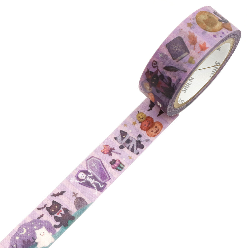 A roll of decorative washi tape with a Halloween pattern, shown partially unrolled on a plain white background. The tape features illustrations of a black cat, pumpkin, ghost, coffin, bat, and stars on a light purple background.