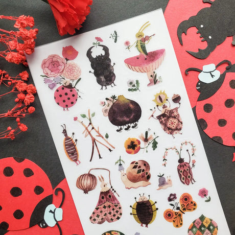 🎻🦗 Take a peek into a bug’s life with @lele_melele, where flower-crowned beetles, violin-playing grasshoppers, sleepy snails, fancy moths, and berry-toting critters are all out here living their best leafy lives. This sheet is like a secret bug party happening under the leaves and we need an invite immediately.

Art by: @lele_melele

One sticker sheet is included.
• Top Coating: None
• Adhesive Layer: Washi
• Backing Layer: Clear PET
• 6.69"x3.54"
• Weight-0.03oz
• 1 Sheet Included