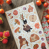 🐹🍎 In @anikeru’s whimsical corner of the woods, autumn’s bounty is gathered by the sweetest of friends. A dapper black cat carries fresh berries, mice and hamsters tuck into plump fruits and seeds, and a toad carries treasures on its back. It’s a season painted in warmth, where every creature has a story to share.