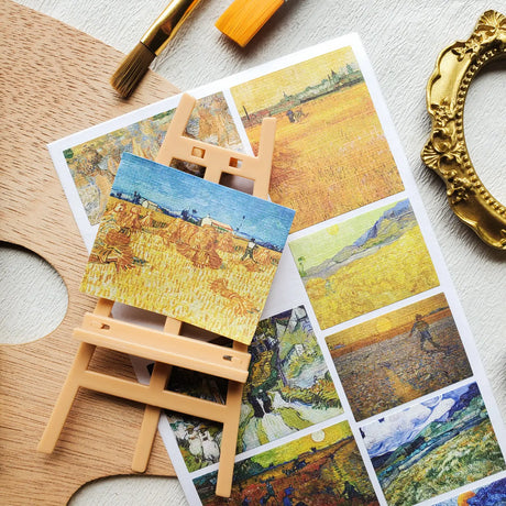 ☀️🖼️ Golden fields stretch beneath swirling skies in this beautiful set of Vincent van Gogh landscapes. From towering haystacks and sunlit harvests to winding village roads, farmhouses, and moonlit wheat fields, each piece captures the warmth, movement, and poetry of the countryside. Rich with glowing yellows, deep blues, and Van Gogh’s unmistakable brushstrokes.

One sticker sheet is included.
• Top Coating: Textured
• Adhesive Layer: Paper
• Backing Layer: Paper
• 6.69" x 3.54"
• Weight - 0.03 oz
• 1 She