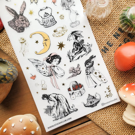 🐇🫖 Somewhere between an old garden journal and a moonlit tea party, @knstartstudio’s enchanting sheet features rabbits in little outfits, winged maidens, buzzing bees, mushrooms, strawberries, roses, and ornate teapots. It’s cottage life with a hint of folklore, perfect for anyone who loves their farmhouse days served with tea leaves, wildflowers, and a little moonlight.

Art by: @knstartstudio

One sticker sheet is included.
• Top Coating: Gold foil
• Adhesive Layer: Washi
• Backing Layer: Clear PET
• 6.