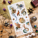 🦄🐉 Soaring through starlit skies and shimmering seas, @hopechristofferson’s mythical beings awaken a realm of untamed magic and ancient wonder. From a winged alicorn and celestial dragons to radiant sirens and cosmic creatures, get ready to weave epic fantasy tales and fill your pages with legendary beauty with this breathtaking sheet.

Art by: @hopechristofferson

Top Coating: Gold Foil
Adhesive Layer: Paper
Backing Layer: Paper
6.69" x 3.54".
Weight - 0.03lbs.
1 sheet included 