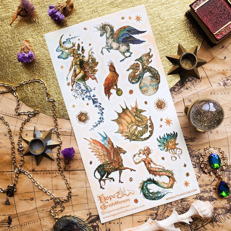 🦄🐉 Soaring through starlit skies and shimmering seas, @hopechristofferson’s mythical beings awaken a realm of untamed magic and ancient wonder. From a winged alicorn and celestial dragons to radiant sirens and cosmic creatures, get ready to weave epic fantasy tales and fill your pages with legendary beauty with this breathtaking sheet.

Art by: @hopechristofferson

Top Coating: Gold Foil
Adhesive Layer: Paper
Backing Layer: Paper
6.69" x 3.54".
Weight - 0.03lbs.
1 sheet included 