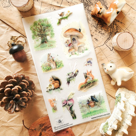 🌳🐿 Wander into a gentle woodland where tiny creatures lead enchanted lives and autumn whispers through the trees with @natachachohraart’s darling set. Where you’ll spot a mouse in a cozy sweater sipping tea outside their mushroom home and even some fairies hitching rides on rabbits through berry-filled gardens.

Art by: @natachachohraart

Top Coating: Matte
Adhesive Layer: Washi
Backing Layer: Clear PET 
6.69" x 3.54".
Weight - 0.03lbs.
1 sheet included         