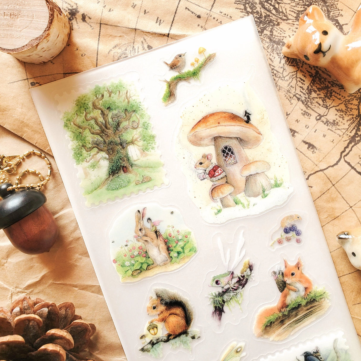 🌳🐿 Wander into a gentle woodland where tiny creatures lead enchanted lives and autumn whispers through the trees with @natachachohraart’s darling set. Where you’ll spot a mouse in a cozy sweater sipping tea outside their mushroom home and even some fairies hitching rides on rabbits through berry-filled gardens.

Art by: @natachachohraart

Top Coating: Matte
Adhesive Layer: Washi
Backing Layer: Clear PET 
6.69" x 3.54".
Weight - 0.03lbs.
1 sheet included         