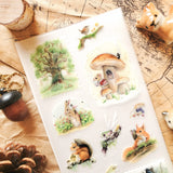 🌳🐿 Wander into a gentle woodland where tiny creatures lead enchanted lives and autumn whispers through the trees with @natachachohraart’s darling set. Where you’ll spot a mouse in a cozy sweater sipping tea outside their mushroom home and even some fairies hitching rides on rabbits through berry-filled gardens.

Art by: @natachachohraart

Top Coating: Matte
Adhesive Layer: Washi
Backing Layer: Clear PET 
6.69" x 3.54".
Weight - 0.03lbs.
1 sheet included         
