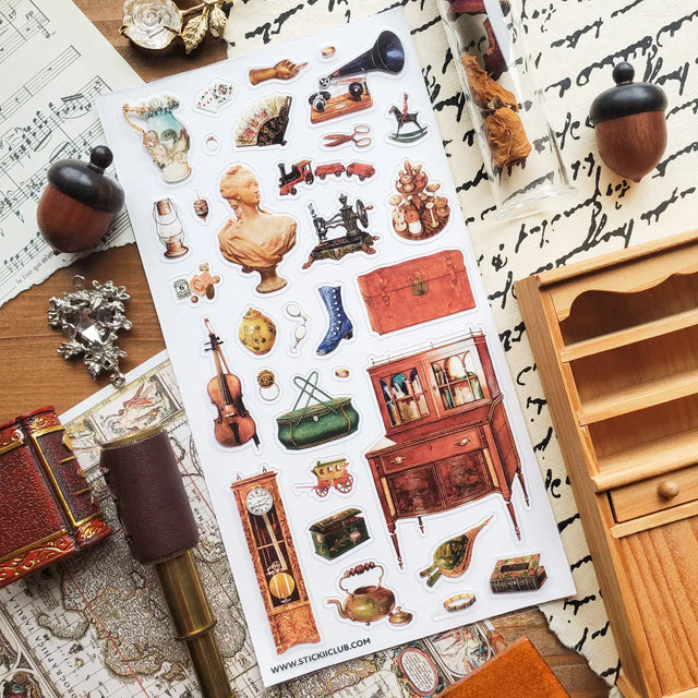 STICKII - Treasured Antiques Sticker Sheet

🕰️🧳 Brimming with timeworn treasures, this sheet feels like a quiet afternoon spent wandering through an antique shop. From ornate clocks and old sewing machines to travel trunks, violins, gramophones, and carefully kept curios, each piece captures the charm of objects with a story to tell. Perfect for adding a little old-world elegance, mystery, and nostalgia to your pages.

Top Coating: None
Adhesive Layer: Paper
Backing Layer: Paper
6.69" x 3.54".
Weight - 0.