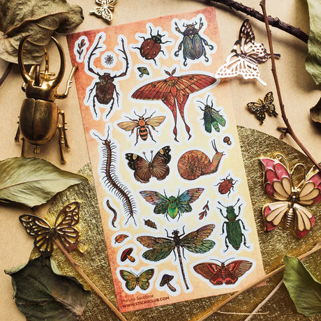 🪲🦋 Bugs get the grand treatment in this striking collection of richly detailed beetles, moths, butterflies, cicadas, and other curious crawlers! Dressed in jewel-toned greens, fiery reds, burnished golds, and intricate patterns, these tiny creatures prove that the insect world can be every bit as bold and beautiful as it is wonderfully wild.

One sticker sheet is included.

• Top Coating: Gold foil
• Adhesive Layer: Paper
• Backing Layer: Paper
• 6.69" x 3.54"
• Weight: 0.03 oz