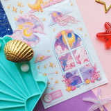 Sticker sheet with celestial design featuring stars, moons, and windows on a pink background.