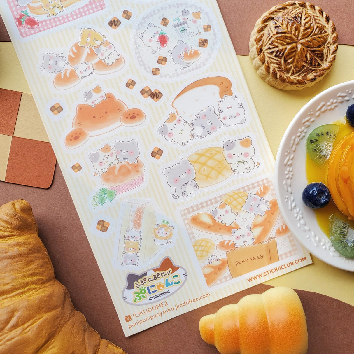 🍞🐱 Soft, sweet, and baked with pure cuteness! @illustratortokudome’s kawaii kitties are lounging on fluffy pancakes, snuggling in fresh baguettes, and baking like purr-fect pros. Every buttery pastry and sugar-dusted treat comes with a tiny paw print of charm.

Art by: @illustratortokudome

Top Coating: None
Adhesive Layer: Paper
Backing Layer: Clear PET
6.69" x 3.54".
Weight - 0.03lbs.
1 sheet included&nbsp;