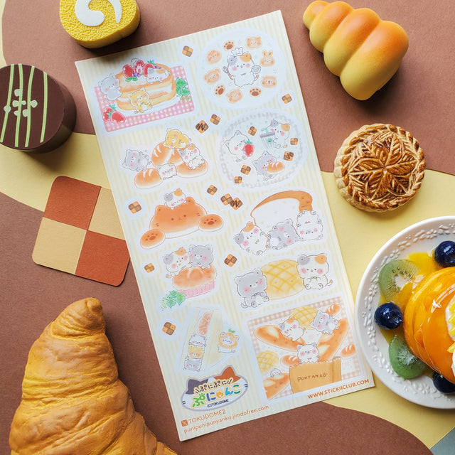 🍞🐱 Soft, sweet, and baked with pure cuteness! @illustratortokudome’s kawaii kitties are lounging on fluffy pancakes, snuggling in fresh baguettes, and baking like purr-fect pros. Every buttery pastry and sugar-dusted treat comes with a tiny paw print of charm.

Art by: @illustratortokudome

Top Coating: None
Adhesive Layer: Paper
Backing Layer: Clear PET
6.69" x 3.54".
Weight - 0.03lbs.
1 sheet included&nbsp;