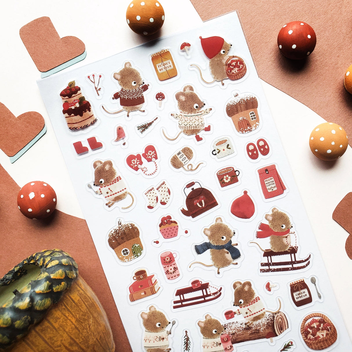 🐭☕️ Cozy up with @nettleandtwig’s snug little mouse village, where winter days are filled with woolly sweaters, steaming cocoa, and muffins fresh from the oven! Among snow-dusted acorn cottages, these tiny friends spend their time sledding, knitting, and sharing warm moments by the fire.

Top Coating: None
Adhesive Layer: PVC (plastic)
Backing Layer: Clear PET
6.69" x 3.54".
Weight - 0.03lbs.
1 sheet included&nbsp;