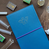 Time to add a little magic to your sticker stash! ✨ Our new Halloween duo has arrived — two perfectly spooky (and irresistibly cute) organizers ready to keep your collection spellbound all season long. Whether you're brewing up cozy crafts or flying into spooky season fun, these organizers will keep your collection safely tucked away in style! 💫

Each organizer features a vegan leather cover with a shimmering gold foil emblem and holds up to 48 sticker sheets across 24 pages.