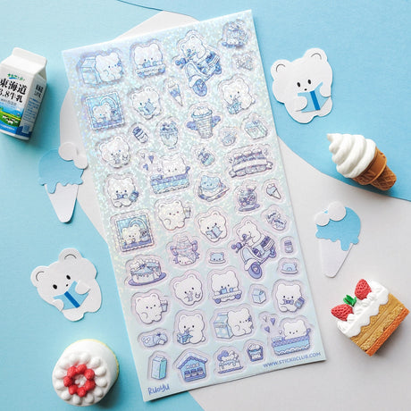 🐻🍰 Get ready for a beary sweet day with this cozy cafe crew! These fluffy bears are serving up smiles, sipping milk, and hustling tasty treats from one adorable moment to the next. From scooter snack deliveries to dessert-filled daydreams, every scene is sprinkled with sugar, warmth, and charm. It’s a treat that’s simply un-bear-ably adorable!

Top Coating: Holo glitter
Adhesive Layer: Paper
Backing Layer: Clear PET
6.69" x 3.54".
Weight - 0.03lbs.
1 sheet included&nbsp;