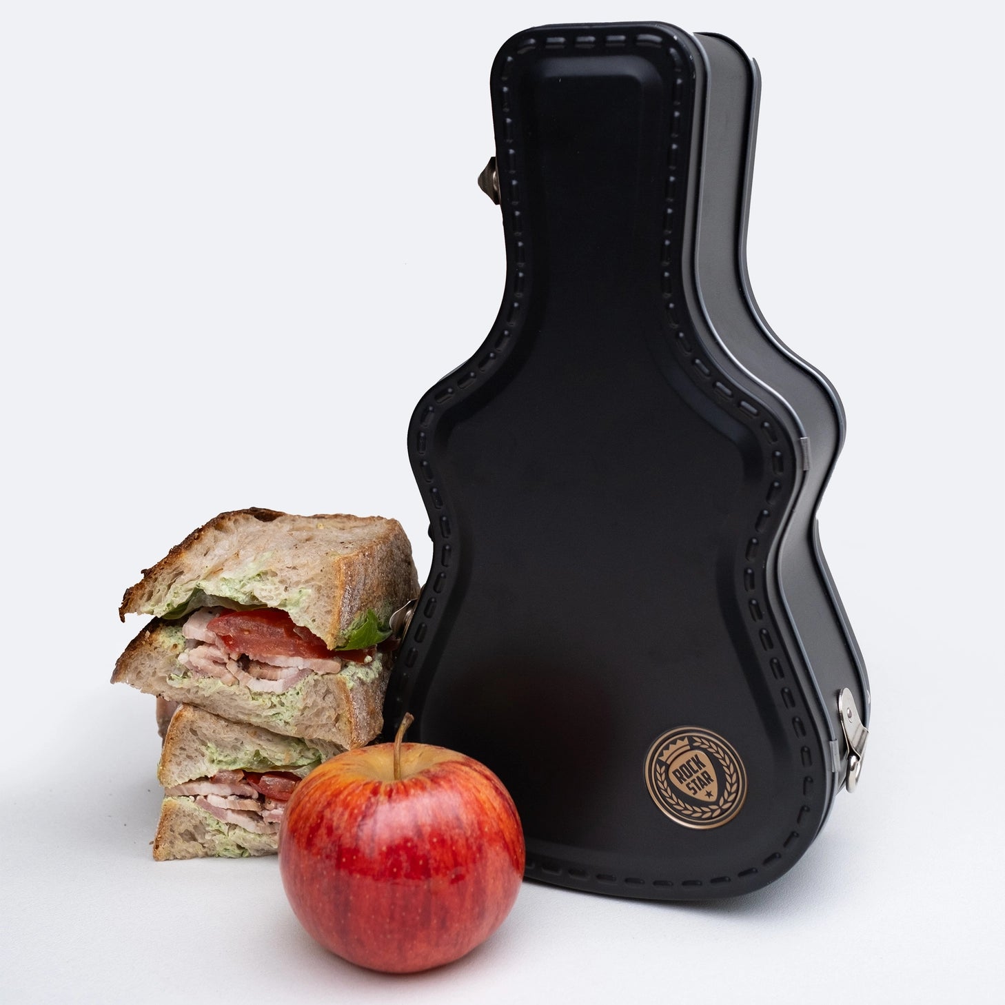 Lunch just got loud. This guitar-shaped tin lunchbox brings rock-n-roll attitude to school, work, or picnics. Keep sandwiches and snacks secure with a sturdy latch and carry handle, then personalise your case with the included set of stickers – just like a real tour pro. Made from durable, food-grade tin and designed to last, it’s the coolest way to carry your lunch on the road.
