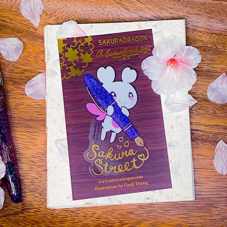 Sakuradragon - Sakura Street Fountain Pen Clear Vinyl Sticker

Sakuradragon really look like she's shining with that pen.

Product Details:

• Material: PET (clear plastic - oil proof, UV resistant, and waterproof)
• Dimensions: 3.5in x 2.37in
• Foil: Gold
