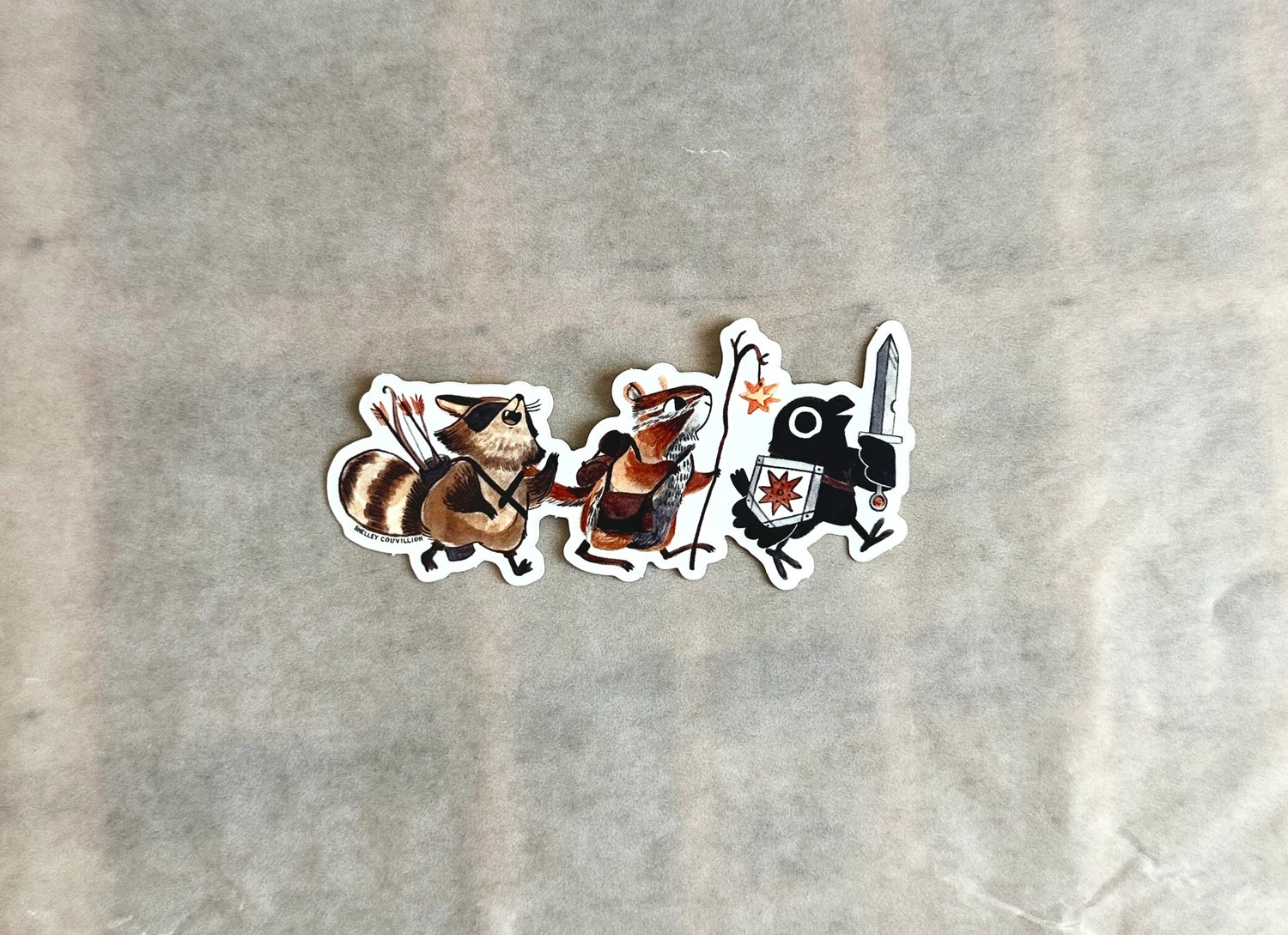This adventuring part consists of a crow with a sword, a magic user who is a chipmunk and a rogue raccoon. But what raccoon is anything besides a rogue? They already have the mask! These three are ready for whatever dragons or dungeons they come across. D&D is one of my favorite activities and I'm having a hard time not making it my whole personality. 

Vinyl and water resistant, looks great on water-bottles or notebooks or laptops. 4.25" wide
