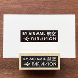 Stamp Marche Air Mail Wooden Stamp Two 'By Air Mail Par Avion' stamps on a wooden surface with a white card.