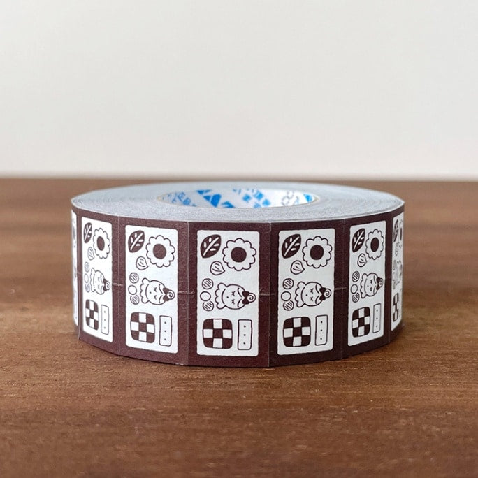 Stamp Marche Label Sticker Roll - Cookie Tin Brown Roll of decorative tape with a pattern on a wooden surface