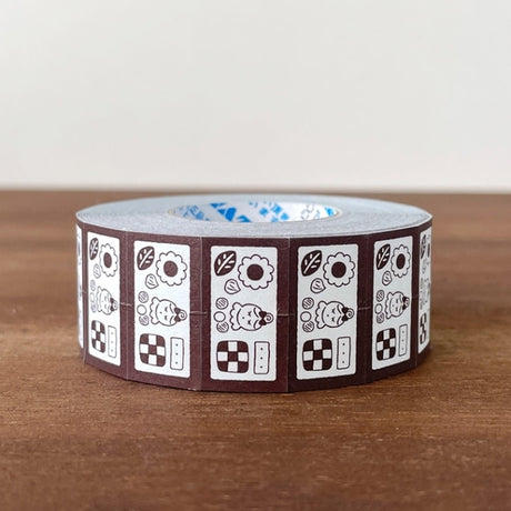 Stamp Marche Label Sticker Roll - Cookie Tin Brown Roll of decorative tape with a pattern on a wooden surface