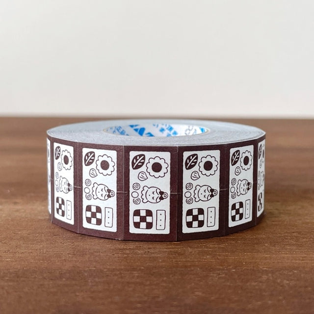 Stamp Marche Label Sticker Roll - Cookie Tin Brown Roll of decorative tape with a pattern on a wooden surface