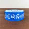 Stamp Marche Label Sticker Roll - Flower Brooch Blue Blue tape with white floral designs on a wooden surface