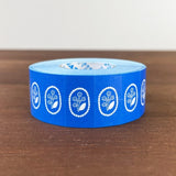 Stamp Marche Label Sticker Roll - Flower Brooch Blue Blue tape with white floral designs on a wooden surface