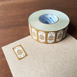 Stamp Marche Label Sticker Roll - Maru-chan Retro Brown Roll of decorative tape with gold designs on a wooden surface