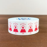 Roll of tape with red illustrations and 'Thank you' text on a wooden surface