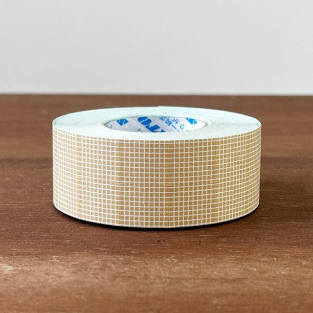 Stamp Marche Label Sticker Roll - Milk Latte Grid Roll of tape with a grid pattern on a wooden surface