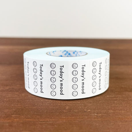 Stamp Marche Planner Label Sticker Roll - Today's Mood Roll of tape with printed text and symbols on a wooden surface