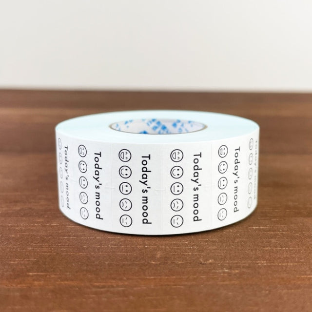 Stamp Marche Planner Label Sticker Roll - Today's Mood Roll of tape with printed text and symbols on a wooden surface