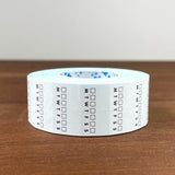 Stamp Marche Planner Label Sticker Roll - Weekly Habit Tracker Roll of tape with calendar markings on a wooden surface