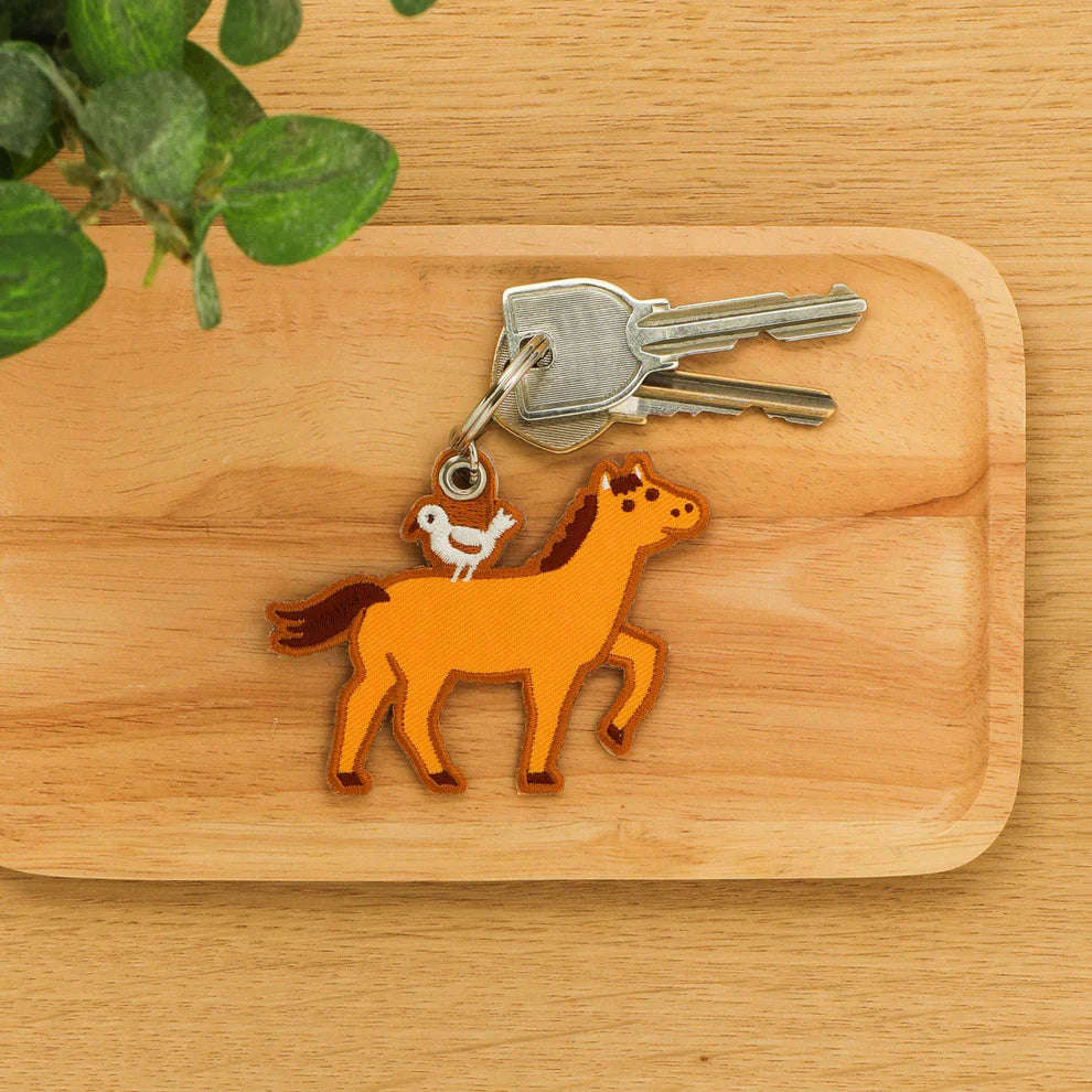 An embroidery keychain featuring the Horse which is the seventh sign of the Chinese zodiac. The horse symbolizes vitality and bold changes. Get lucky to use it as a keychain and a tag for your planner.&nbsp;LNY is February 17th this year!&nbsp;

A little bird perched atop on the brown horse adds a charming accent. The back side is embroidered with the word "uma" in hiragana, meaning a horse in Japanese.&nbsp;