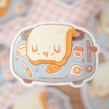 A sticker of floppy Muffinmaru toast struggling to get up in the morning. This sticker has a shiny mirror-like finish on some parts of the toaster for some extra flare. This durable sticker is great for decorating water bottles, laptops, suitcases, and much more!

Dimensions: &nbsp; 2.8" x 2" (7.1cm x 5.1cm)
Material: PET
Waterproof
Quantity: 1 sticker