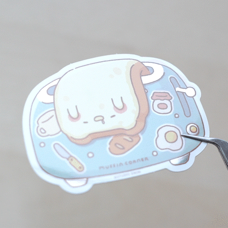 A sticker of floppy Muffinmaru toast struggling to get up in the morning. This sticker has a shiny mirror-like finish on some parts of the toaster for some extra flare. This durable sticker is great for decorating water bottles, laptops, suitcases, and much more!

Dimensions: &nbsp; 2.8" x 2" (7.1cm x 5.1cm)
Material: PET
Waterproof
Quantity: 1 sticker