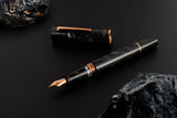 This TWSBI Obsidian fountain pen is made of a dark grey/black swirled acrylic resin, inspired by the natural obsidian stone. The pen is complemented by rose gold-plated trim and is equipped with a rose gold-plated stainless-steel nib.

Pen cap is&nbsp;able to post&nbsp;onto the back of the pen

Piston Filler Fountain pen.
Simply unscrew the end cap, dip into ink, screw back the end cap, and you're done! Ready to write!!