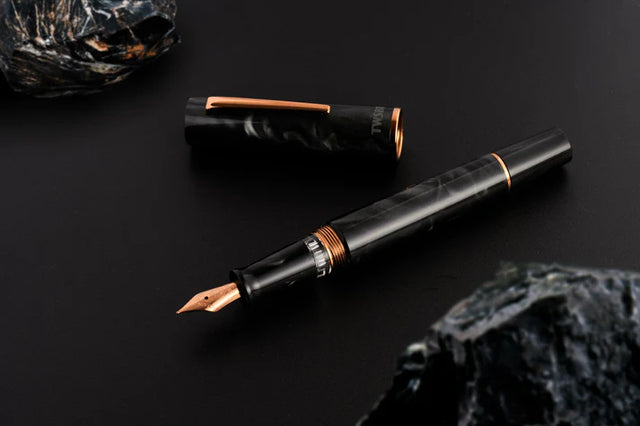 This TWSBI Obsidian fountain pen is made of a dark grey/black swirled acrylic resin, inspired by the natural obsidian stone. The pen is complemented by rose gold-plated trim and is equipped with a rose gold-plated stainless-steel nib.

Pen cap is&nbsp;able to post&nbsp;onto the back of the pen

Piston Filler Fountain pen.
Simply unscrew the end cap, dip into ink, screw back the end cap, and you're done! Ready to write!!