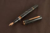 This TWSBI Obsidian fountain pen is made of a dark grey/black swirled acrylic resin, inspired by the natural obsidian stone. The pen is complemented by rose gold-plated trim and is equipped with a rose gold-plated stainless-steel nib.

Pen cap is&nbsp;able to post&nbsp;onto the back of the pen

Piston Filler Fountain pen.
Simply unscrew the end cap, dip into ink, screw back the end cap, and you're done! Ready to write!!