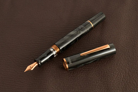 This TWSBI Obsidian fountain pen is made of a dark grey/black swirled acrylic resin, inspired by the natural obsidian stone. The pen is complemented by rose gold-plated trim and is equipped with a rose gold-plated stainless-steel nib.

Pen cap is&nbsp;able to post&nbsp;onto the back of the pen

Piston Filler Fountain pen.
Simply unscrew the end cap, dip into ink, screw back the end cap, and you're done! Ready to write!!